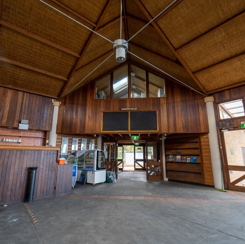 A spacious wooden interior with high ceilings and reminiscent of a rustic hut.