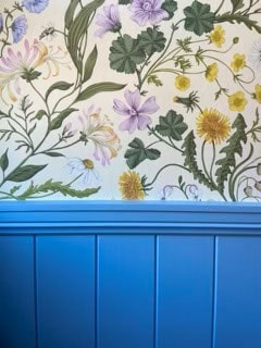 Wallpaper with botanical illustrations of various flowers and leaves above a blue panel.